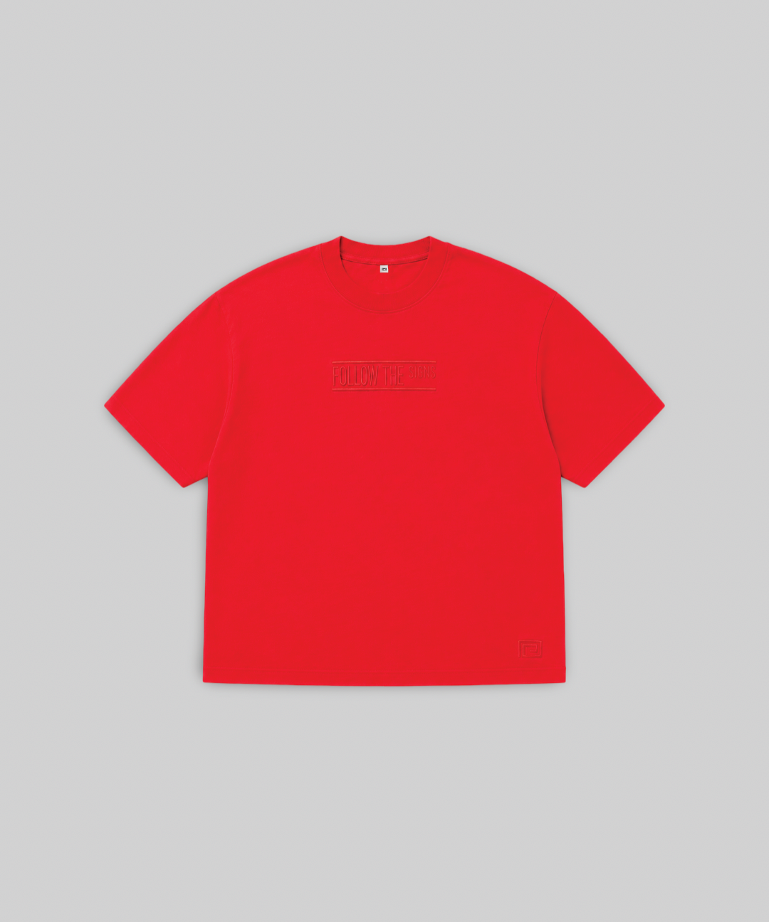 A bright red short-sleeve crewneck t-shirt with a subtle tonal dark red graphic across the chest, displayed flat against a solid light gray background.